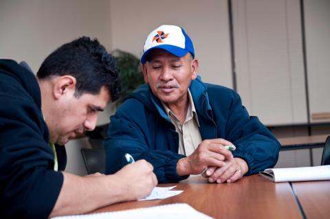 101413clues126.jpg Two men writing at desk