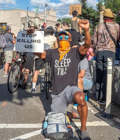 Protester holds up a sign "Stop Killing Us" at a George Floyd protest on June 7, 202 Protester holds up a sign "Stop Killing Us" at a George Floyd protest on June 7, 2020