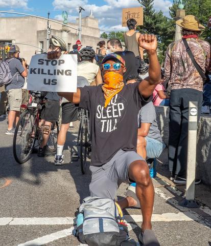 Protester holds up a sign "Stop Killing Us" at a George Floyd protest on June 7, 2020