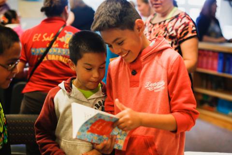 826pic5.jpg Fourth grade students examine new book that contains writing from their class.
