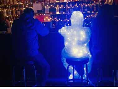 ac-cleveland-lit-figure380.jpg Illuminated figure artwork sitting beside man at a bar