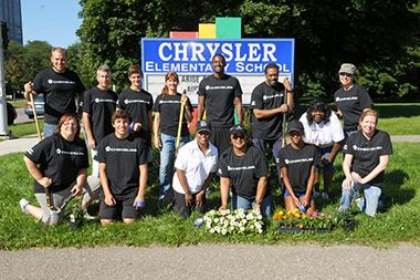 arise-chrysler_lg.jpg Chrysler team poses in front of Chrysler Elementary School sign
