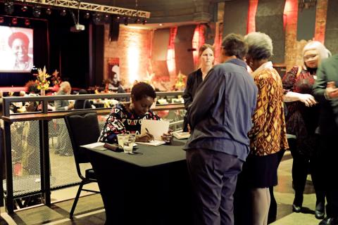 Signing books at reception. Kresge Eminent Artist Gloria House signs copies at her monograph release party.