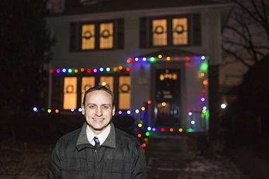 grandmont_rosedale-exterior_lg.jpg Father standing in front of his home lit by Christmas lights