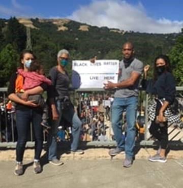 Family attends rally with a Black Lives Matters sign Family attends rally with a Black Lives Matters sign
