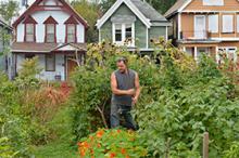 learn.jpg Urban farmer, white male in garden with houses in the background