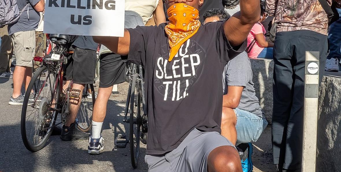 Protester holds up a sign "Stop Killing Us" at a George Floyd protest on June 7, 202 Protester holds up a sign "Stop Killing Us" at a George Floyd protest on June 7, 2020
