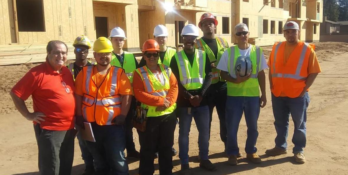 South East Fresno EDC organizes workforce development training for neighborhood residents South East Fresno EDC organizes workforce development training, residents pose for photo at construction site wearing hard hats.