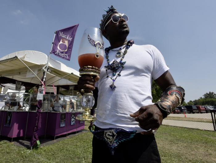 Sevin McClure, Detroit, shows off his hand-made wrist cuffs, necklace, crown, and chalice full of his homemade health juice during the Belle Isle Art Fair, part of the 12th Annual ARISE Detroit! Neighborhoods Day. 