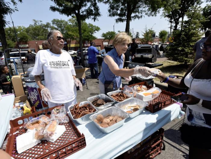Volunteers hand out free hot dogs and hamburgers in the Mike's Market parking lot during Jazz Extravaganza: Jazz on the Avenue, which was part of the 12th Annual ARISE Detroit! Neighborhoods Day. 