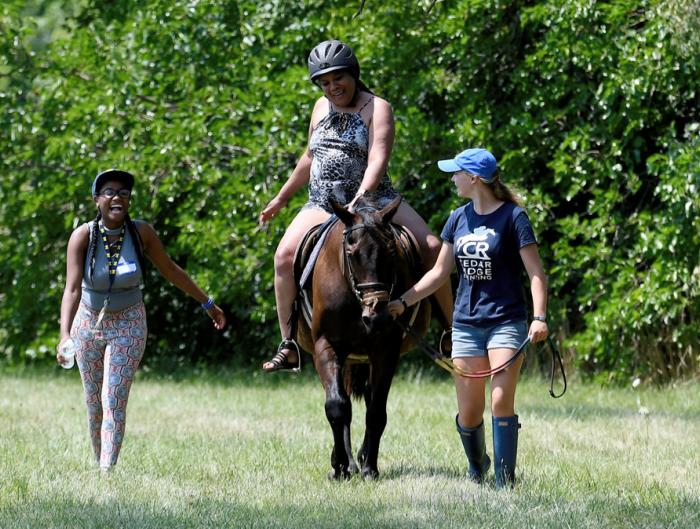 Tangala Howard, North Carolina, on horse, laughs as she pretends to know what she's doing (it was her first time riding a horse) much to the delight of Brianna Brown, left, Detroit, and Mackenzie Pillote, right, Ann Arbor, during the Horse Fair on Linwood Street in Detroit, where novice riders got the chance to experience the joys of riding a horse. 