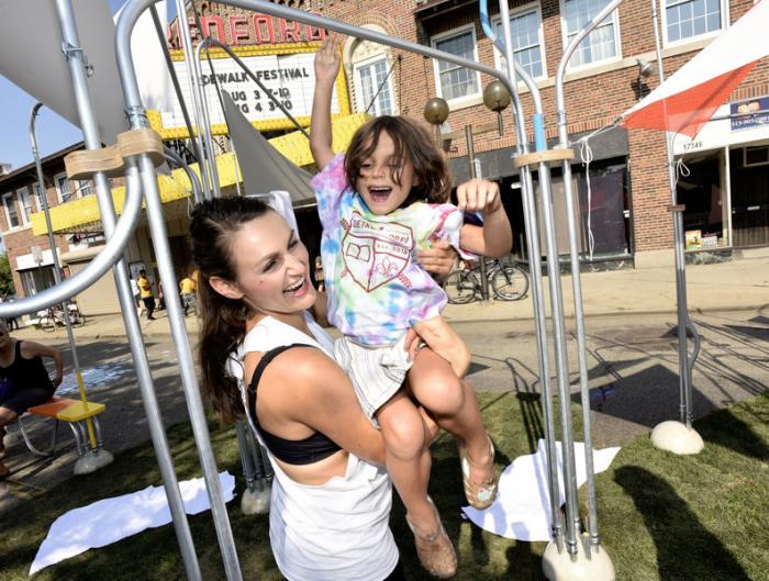 Isabella DeMarco, 5, Detroit, and her mother Tricia, play on one of the installations on the street at the Sidewalk Festival on Detroit's west side during the 12th Annual ARISE Detroit! Neighborhoods Day. 