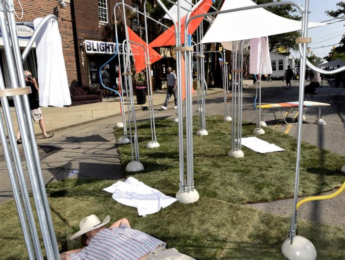 The art installations on the street are enjoyed in a variety of ways, including an afternoon nap, at the Sidewalk Festival on Detroit's west side during the during the 12th Annual ARISE Detroit! Neighborhoods Day. 