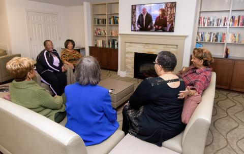 Residents gather to chat and watch TV in the Hartford Village community room