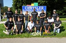 Chrysler team poses in front of Chrysler Elementary School sign