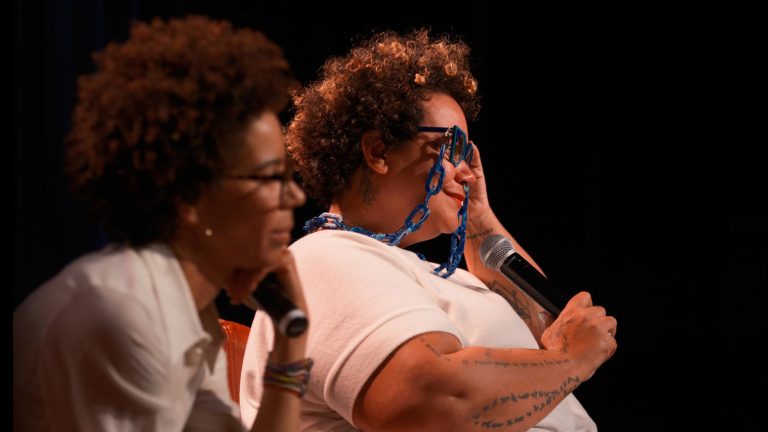 Two Black women, Ayana Elizabeth Johnson (left) and adrienne marie brown, are sitting with microphones discussing their books.