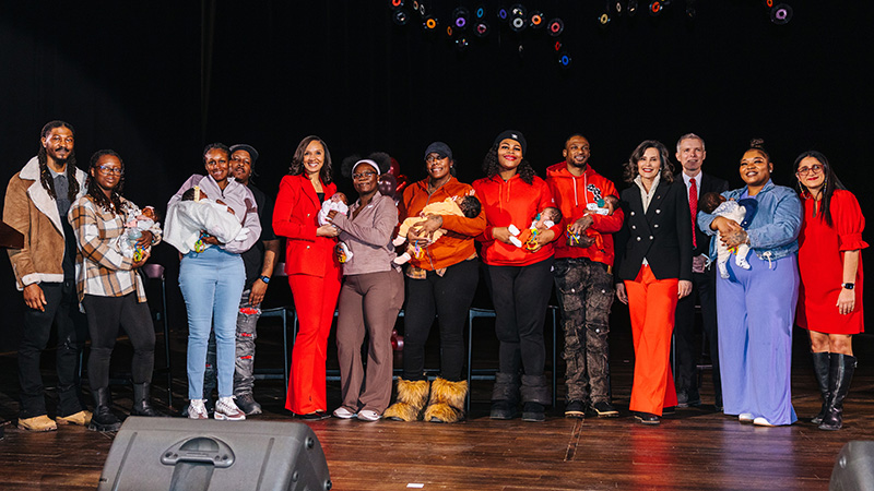 A line of people with sets of families with their babies and local and state politicians. ir babies