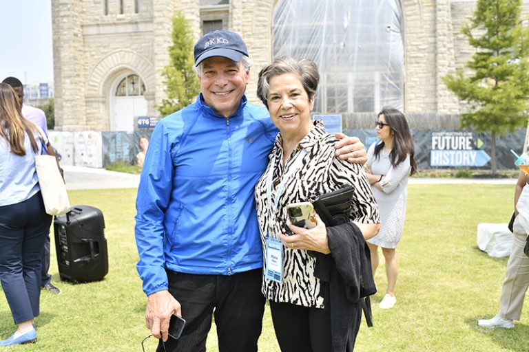 Kresge Board of Trustees James L. Bildner and Maria Otero stand together in front of a church being renovated.