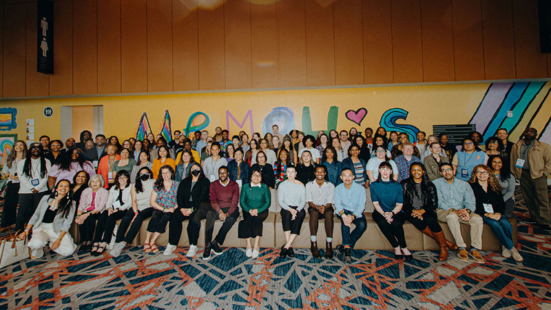 A large group of more than 100 people gather together for a group photo.