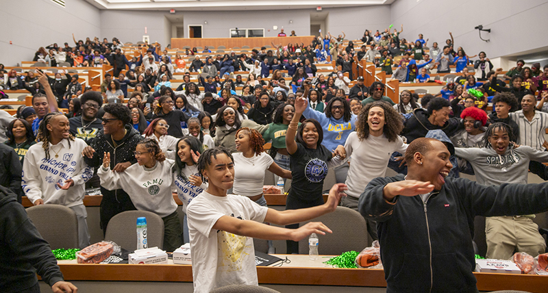 An auditorium full of high school students celebrate in College Decision Day 