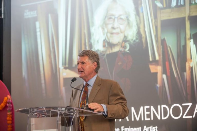 Kresge President & CEO Rip Rapson at a lectern with an image of Kresge Eminent Artist Nora Chapa Mendoza on the screen behind her.