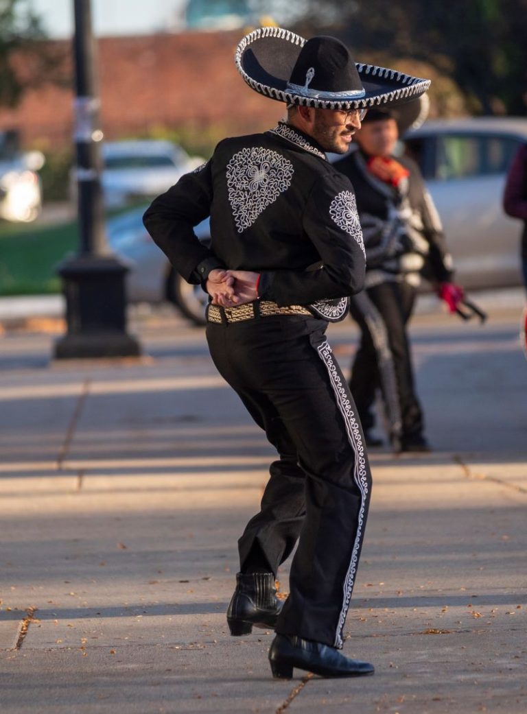 A performance by the Milagro Compañía de Ballet Folklórico with a man in black sombrero, jacket and pants trimmed in white.