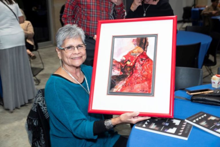 A woman displays some of Nora Chapa Mendoza's art