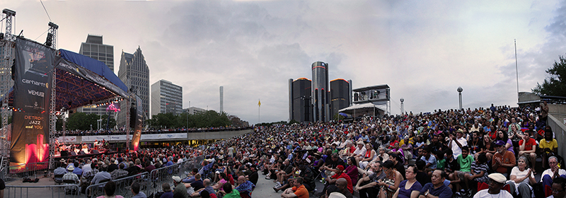 A mass crowd of people watch an outdoor jazz performance in downtown Detroit