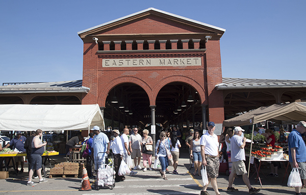 A large brick structure with arched entryways and the sign Eastern market at the top.