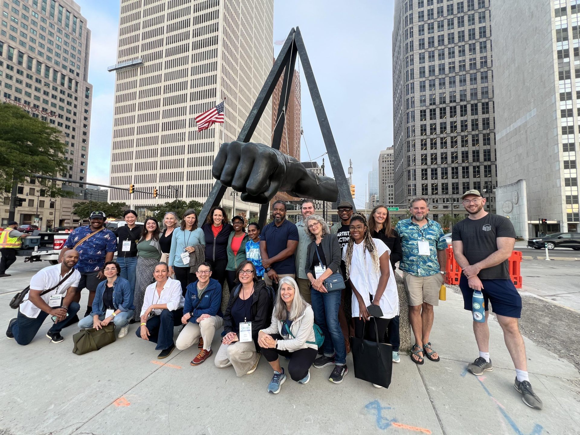 A group of people pose in front of the Joe Louis fist sculpture in downtown Detroit.