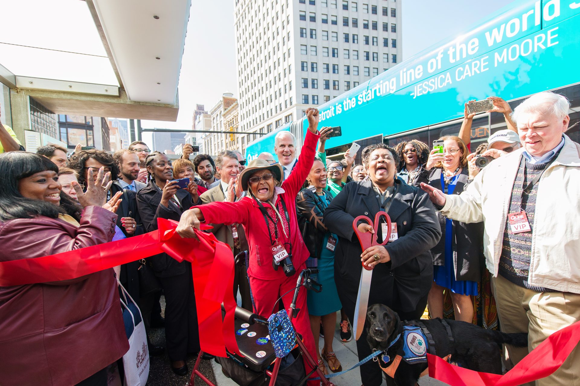 A large group of people celebrate at the ribbon cutting ceremony of Detroit's QLine light rail.