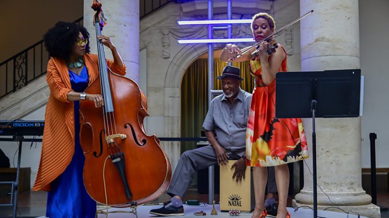 Marion Hayden on left playing bass, Mahindi Masai and Michelle May playing violin at the Kresge at 100 celebration at the Detroit Institute of Arts courtyard.