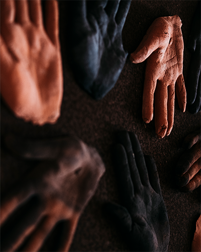 A ceramic art piece depicting several hands