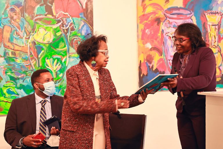 Kresge's Wendy Lewis Jackson hands a ceremonial first copy of "A Palette for the People" to Shirley Woodson.