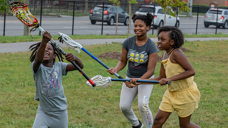 Three young children play in Zussman Park in Detroit