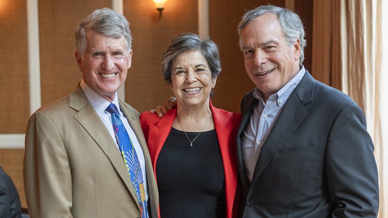 Kresge President Rip Rapson and Trustees Maria Otero and James Bildner stand next to each other in a restaurant.