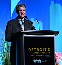 Kresge President & CEO Rip Rapson at a podium with the sign: Detroit & The American City A Kresge Centennial Symposium