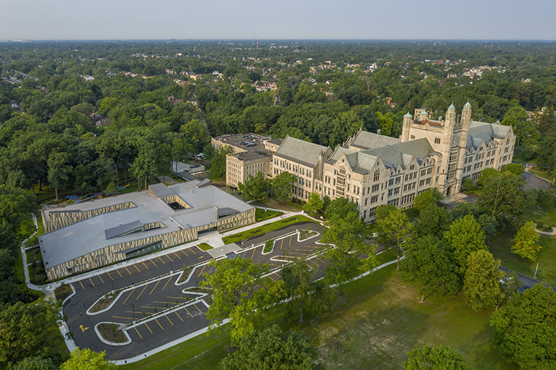 An aerial view of the Marygrove campus with a modern early childhood center on the left and a Gothic-style architecture building on the right)