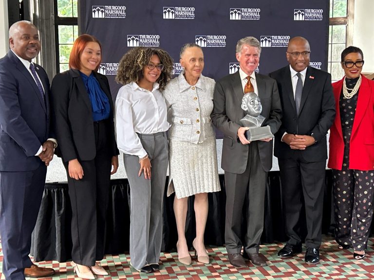 Kresge President & CEO Rip Rapson, holding an award in the shape of the bust of Thurgood Marshall, stands with six people that attended the Thurgood Marshall College Fund event.