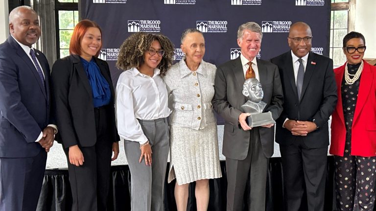 Kresge President & CEO Rip Rapson, holding an award in the shape of the bust of Thurgood Marshall, stands with six people that attended the Thurgood Marshall College Fund event.