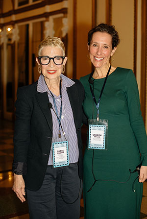 Two women with lanyards stand together for a photo.