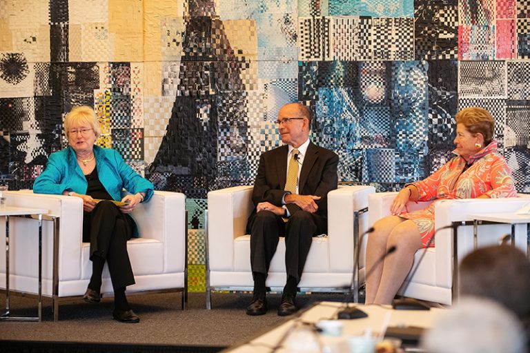 A photo of Nancy Schlichting, Paul Hillegonds and Elaine Rosen sitting in chairs against a colorful mural during their final Kresge board meeting in June 2022.