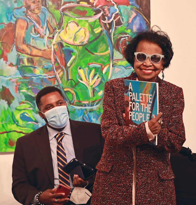 Shirley Woodson smiles broadly while holding a copy of the new monograph on her life and work.