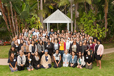 A large group photo of Kresge's Climate Resilience and Urban Opportunity (CRUO) initiative seen in front of a gazebo and lush gardens and trees. 