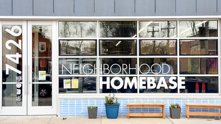 The front of a building with lots of glass window s and a sign: 7426 Neighborhood Homebase