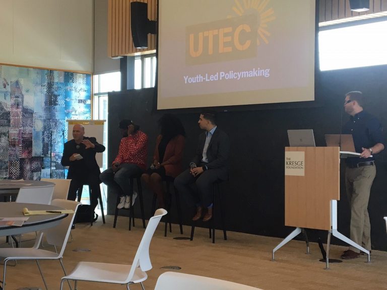 A panel of five people from UTEC give a presentation in the Kresge convening center.